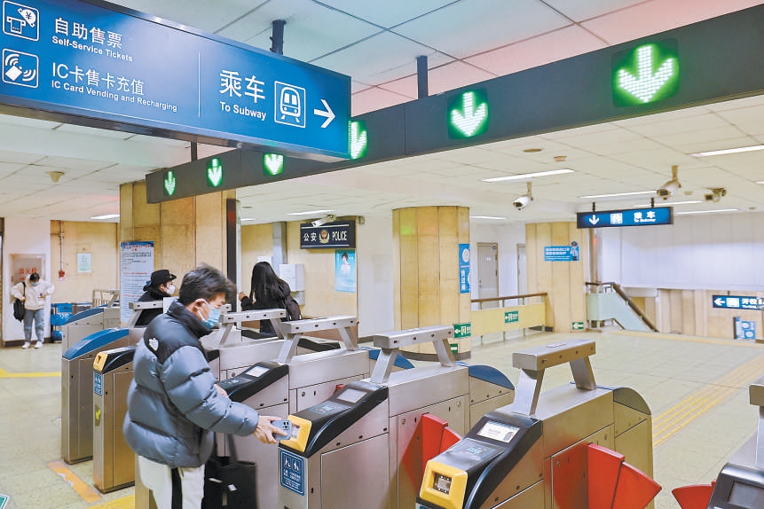 昨天,在地铁2号线安定门站,乘客刷码进站.本报记者邓伟摄