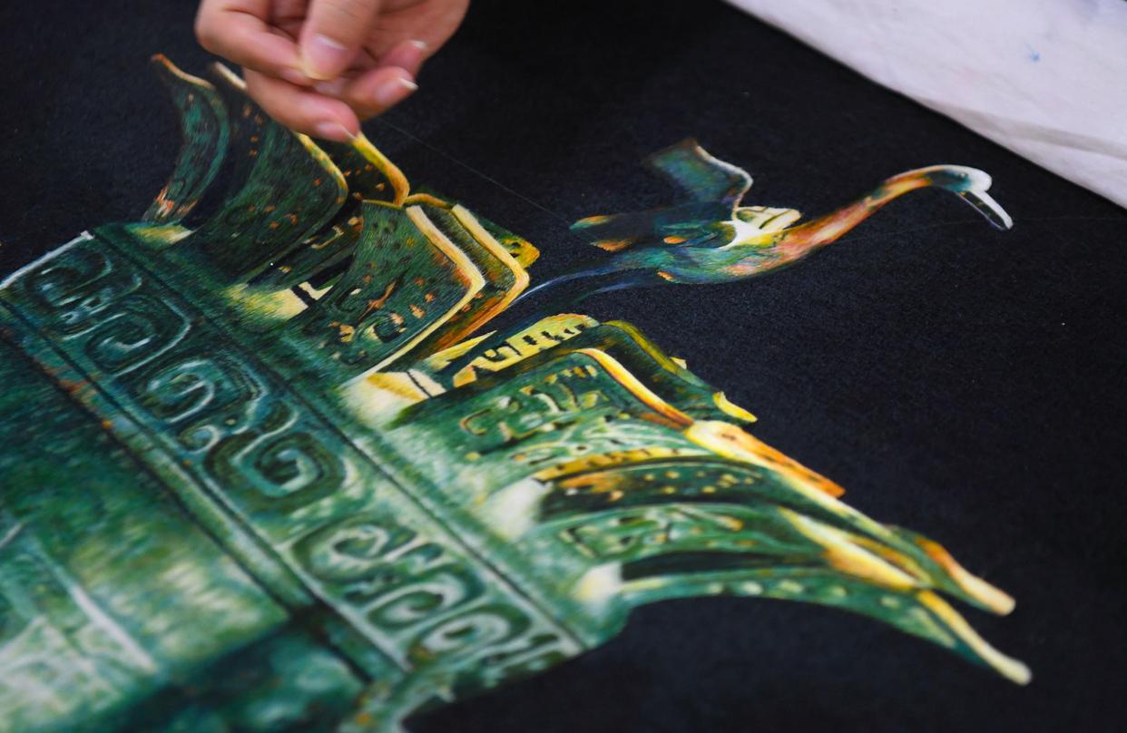 在广州市荔湾区的工作室,王新元在制作一件以青铜器为主题的广绣作品