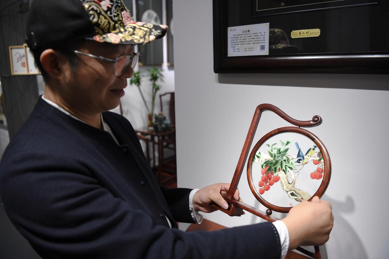 在广州市荔湾区的工作室,王新元展示传统广绣作品(12月6日摄).