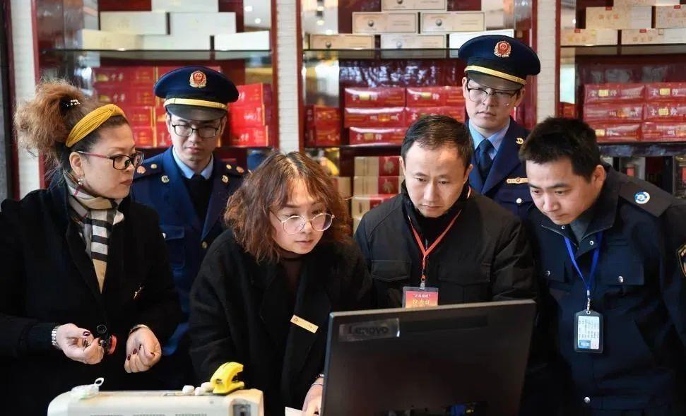 △在浙江省宁波市北仑区，联合检查组的工作人员在一家烟酒商店浏览发票记录，核查是否有违规公款消费等情况（2020年1月8日摄）。