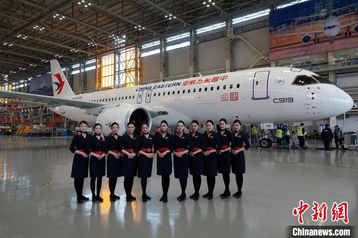 东航空乘代表与c919全球首架交付飞机合影. 中新社记者 孙自法 摄