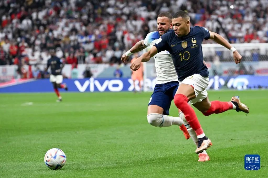 12月10日，法国队球员姆巴佩（右）与英格兰队球员沃克在比赛中拼抢。新华社记者 李尕 摄