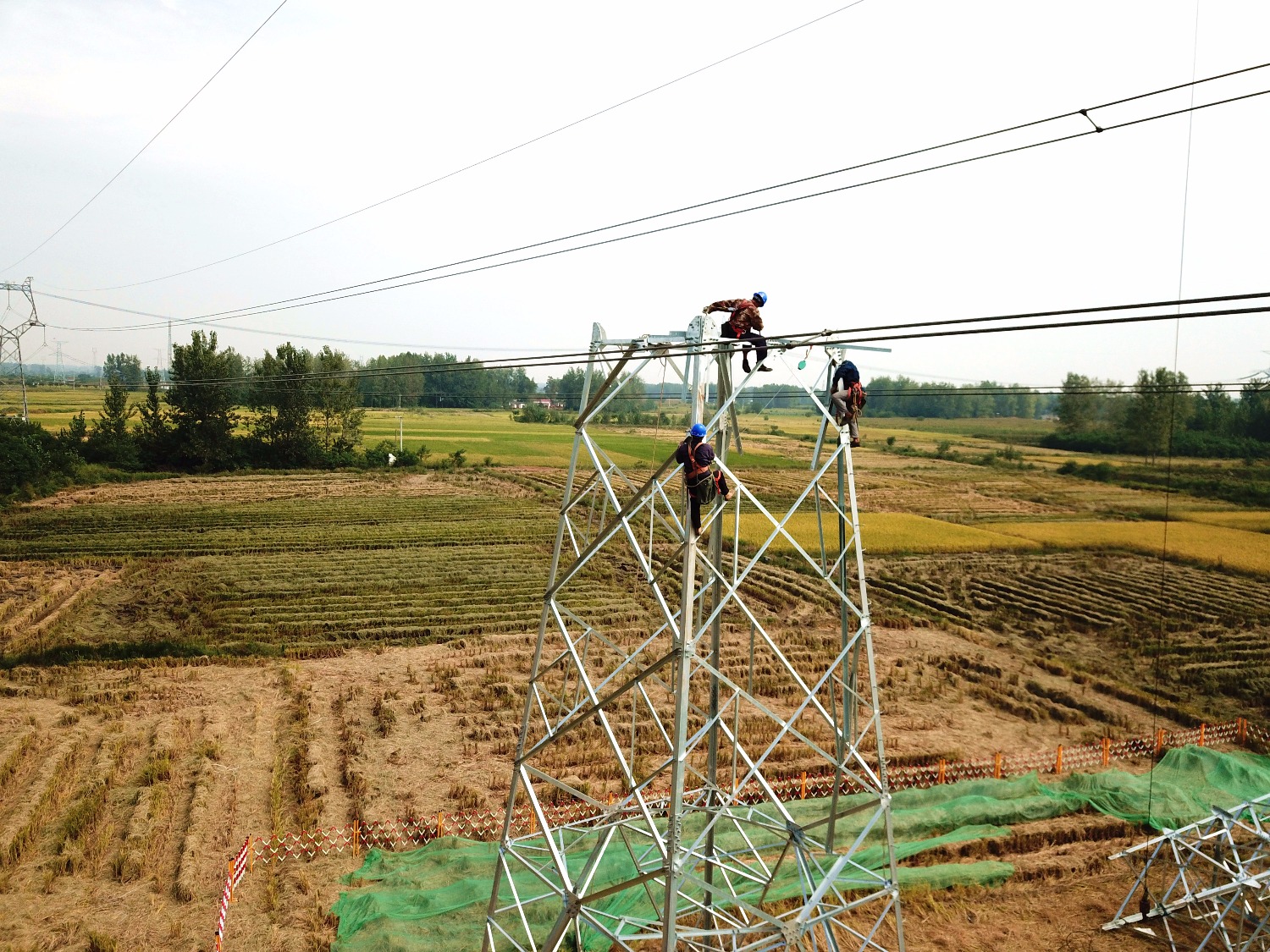 110kv&nbsp;线路施工现场,施工人员在组建110千伏输电杆塔