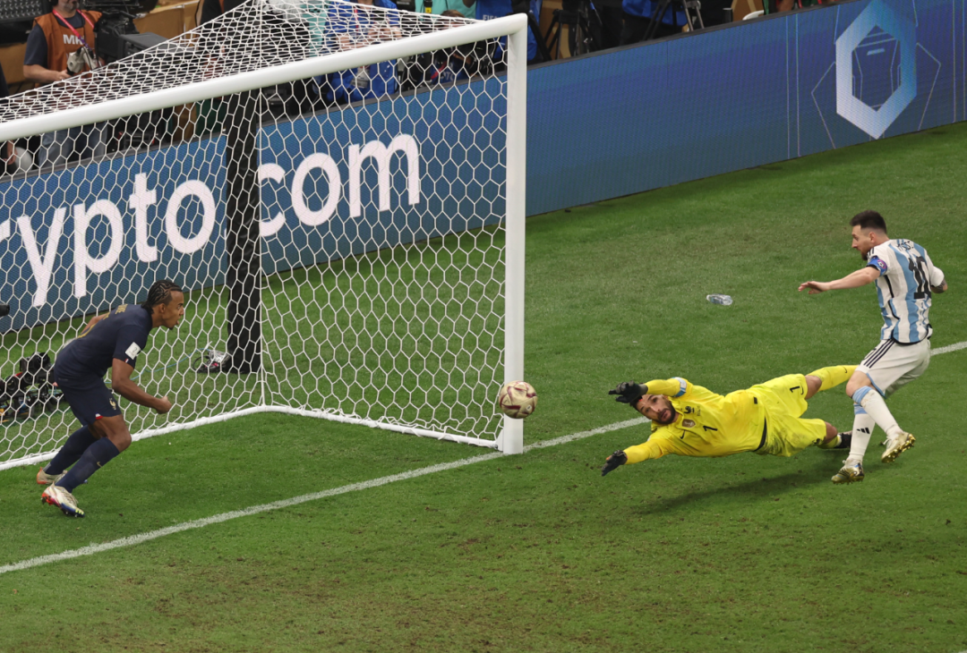 12月18日,阿根廷队球员梅西(右)在加时赛中射门得分.