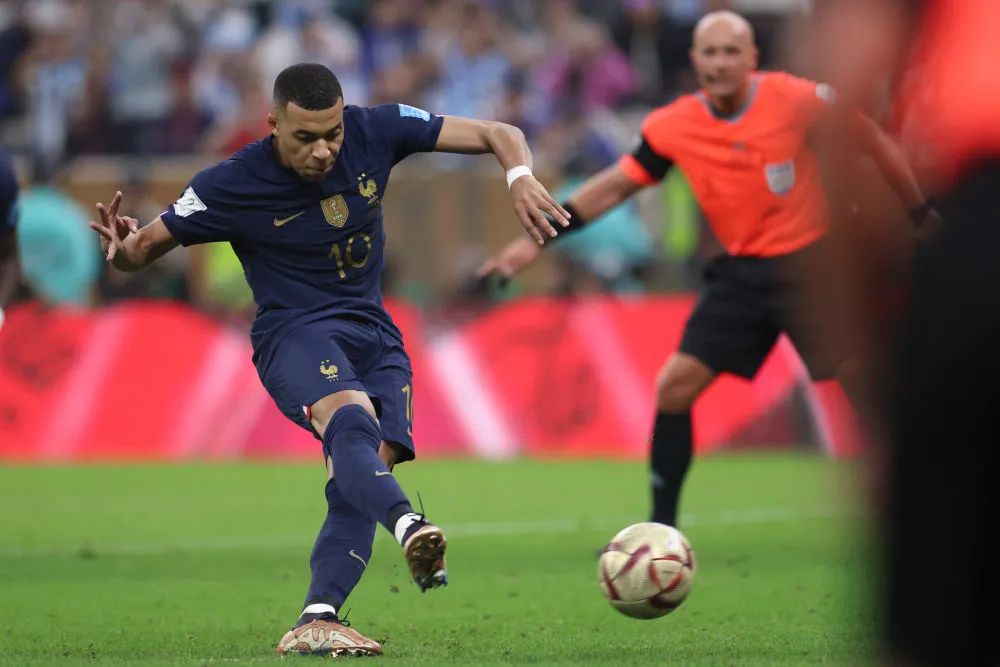 12月18日,法国队球员姆巴佩(左)在世界杯决赛中主罚点球得分.