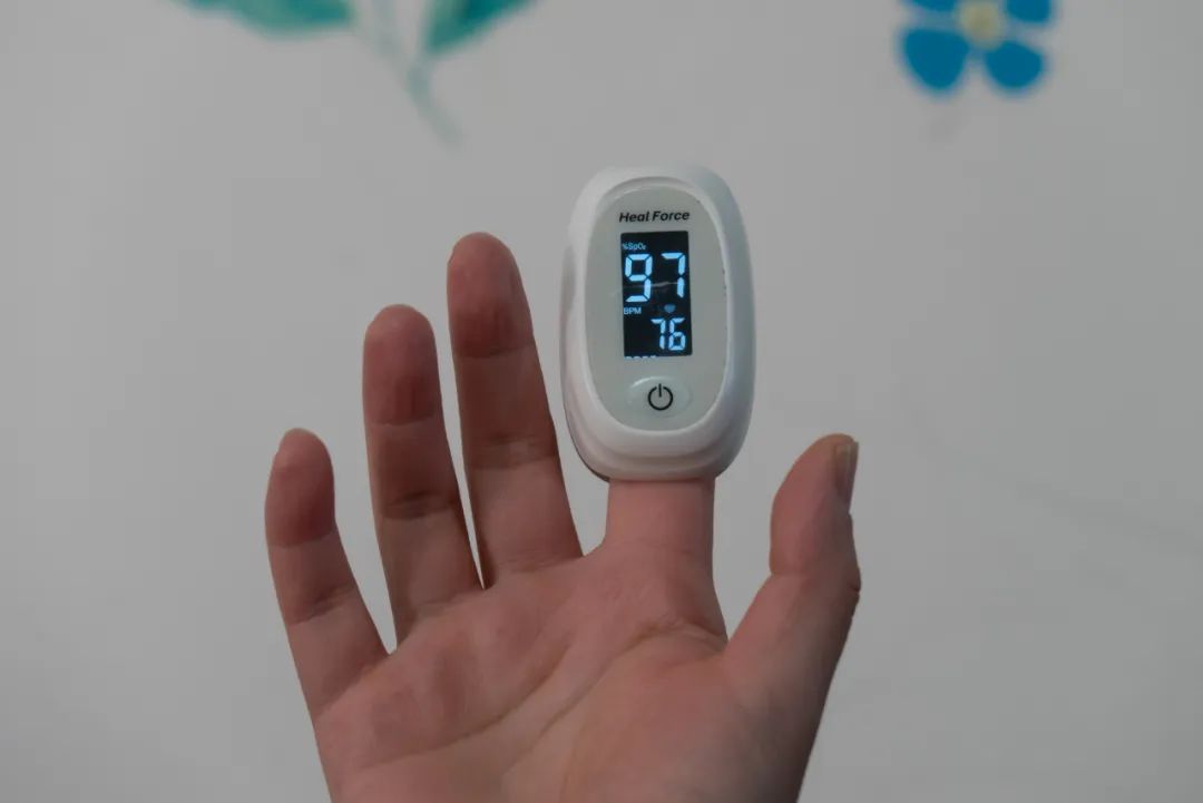 2022年12月18日,上海,市民在家中通过指夹式血氧仪测量血氧饱和度和