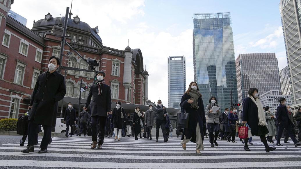 当地时间2022年12月28日,日本东京站前,戴着口罩上班的上班族.