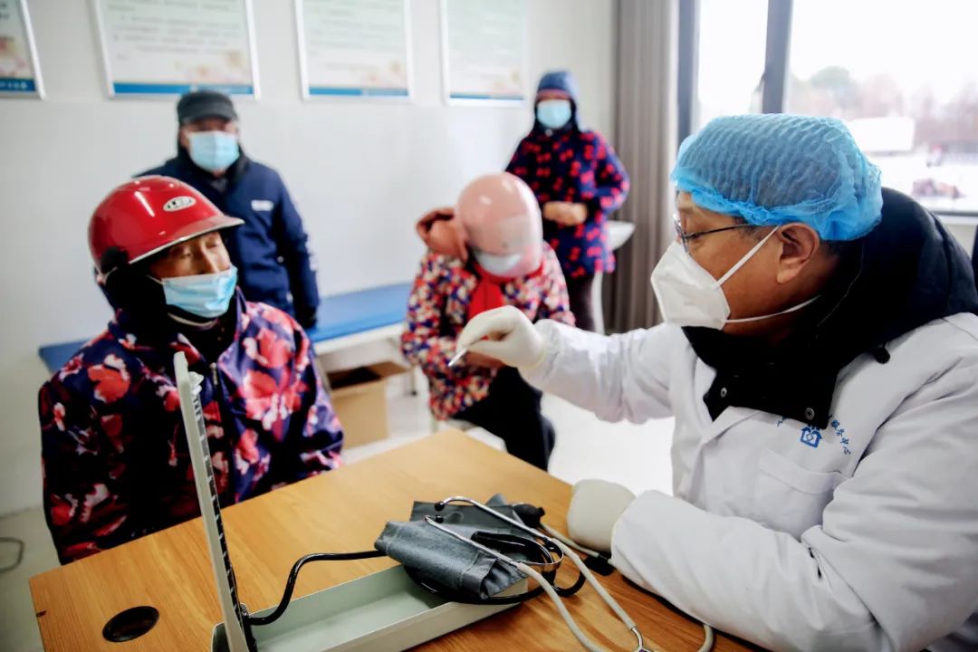 2022年12月26日，江苏如皋市，如城街道长港村卫生室医务人员正在接诊中。图/中新