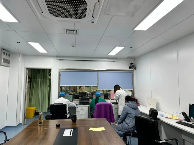 　　许宝华主任(左一)和祁伟医师(左二)一起在为患者紧急安排住院,他们对面的抢救室里已经躺满了患者