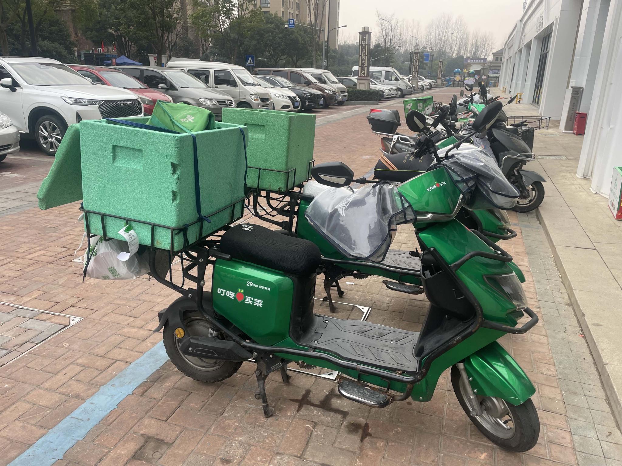 水产等岗位的工作人员正在紧张忙碌,配送小哥拎着大包小包在电动车上