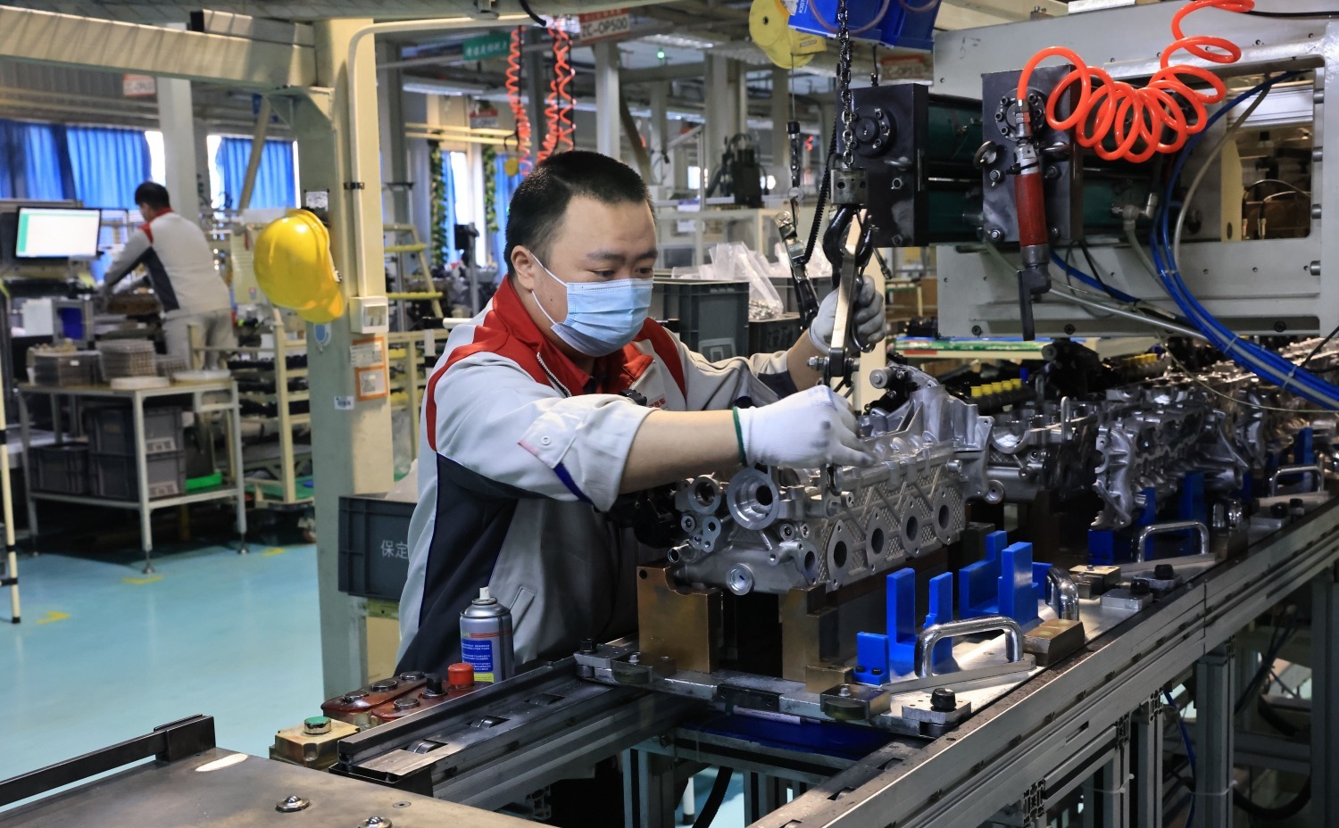 图为在企业发动机组装车间,工人正在组装发动机