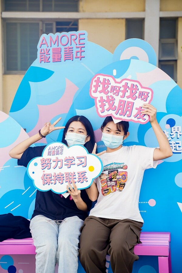 　　2022年“AMORE能量青年”公益项目现场，两名学生在合影区留念
