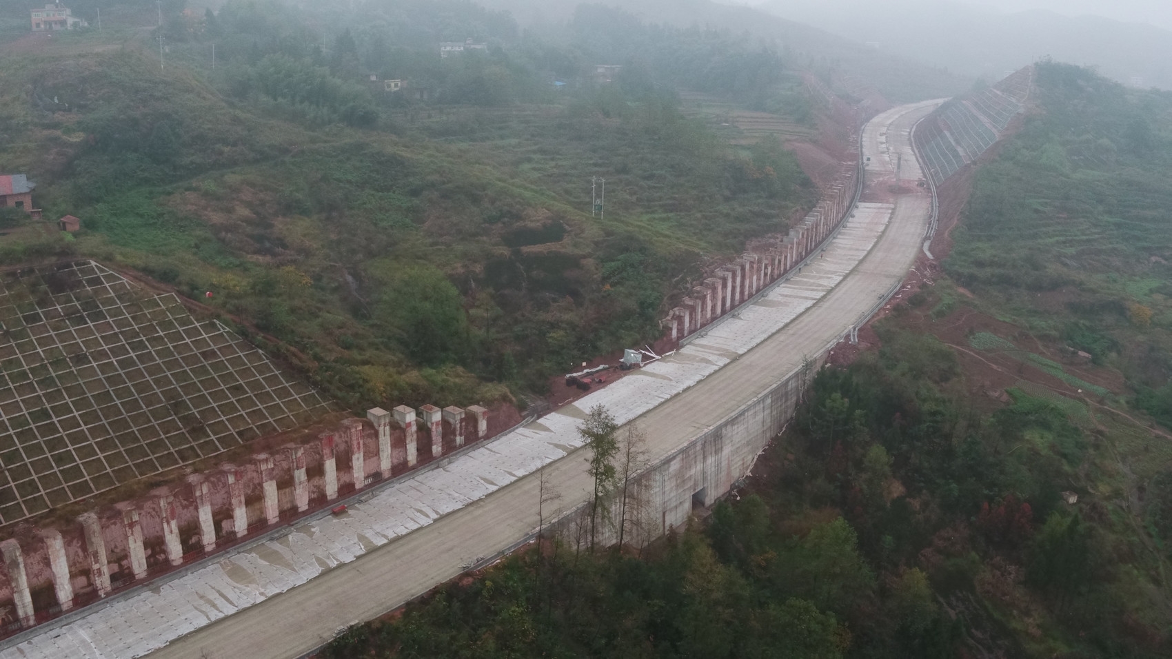 南北大道三期邻水段边坡抗滑桩处正在进行桩板墙施工作业.冯强 摄