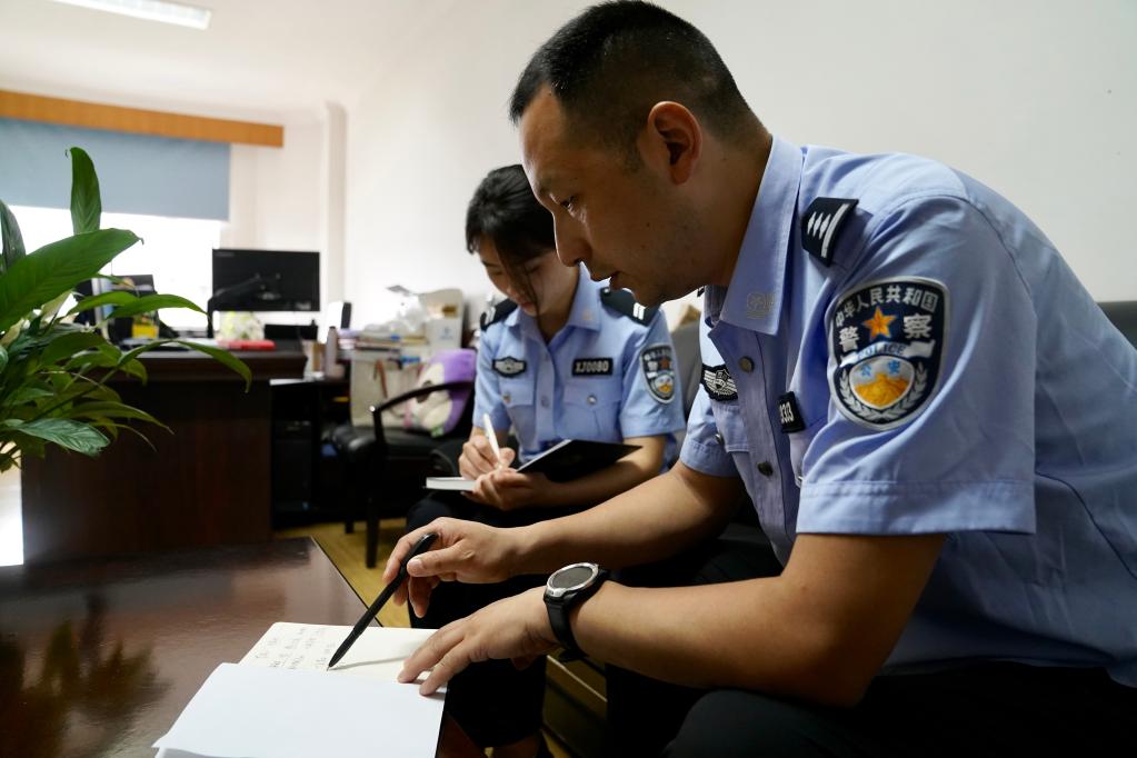 民警胡祥雨(右)与同事在工作中.(绵阳市公安局供图)