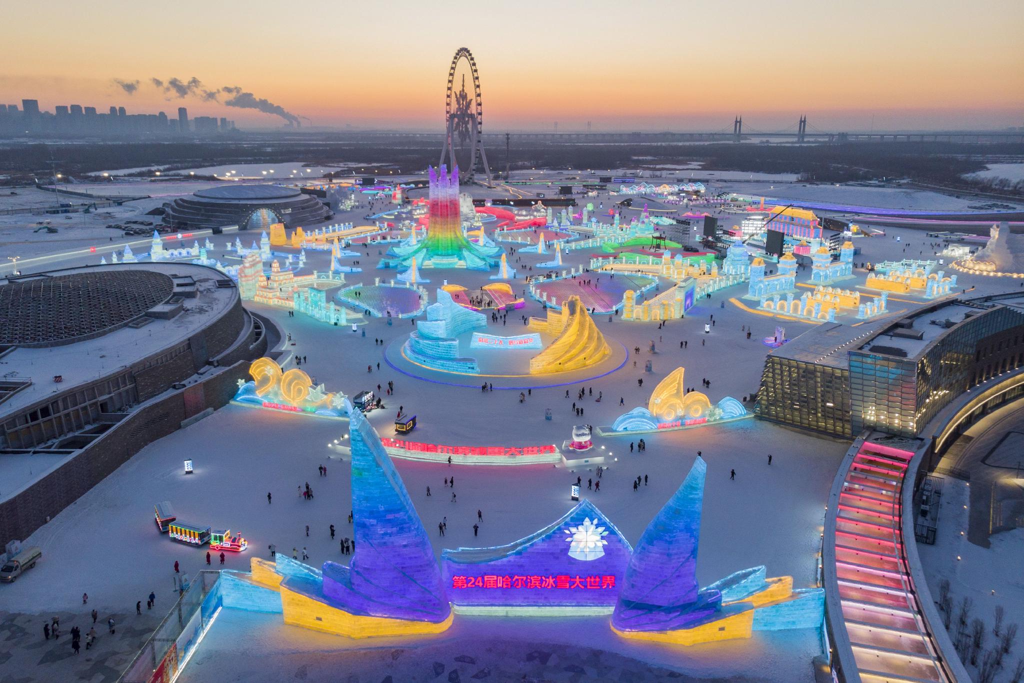 这是1月3日拍摄的夕阳下的第24届哈尔滨冰雪大世界园区(无人机照片).