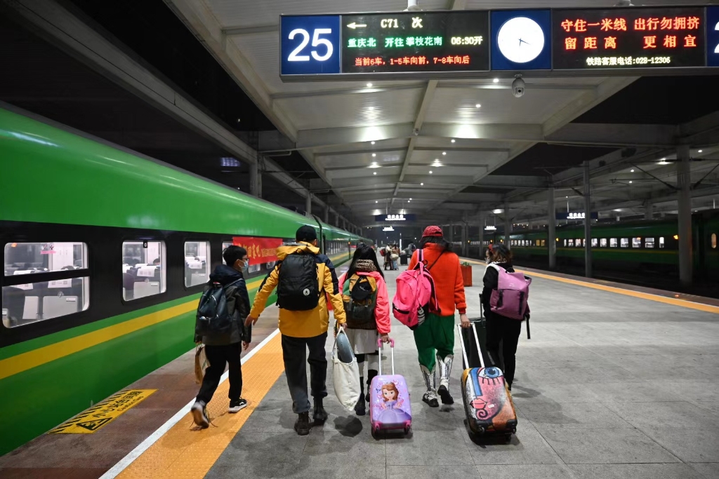 这家人的背影让人不禁想问:你们是回家,还是出游?(通讯员 钟洁 摄)