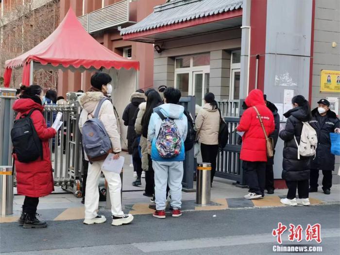 北京一考点外，考生正在排队进入考场 刘欢 摄