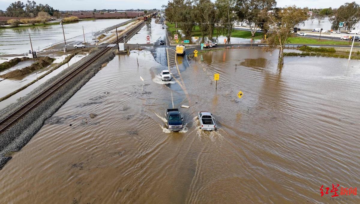 ↑美国加州，车辆在被洪水淹没的道路上艰难行驶
