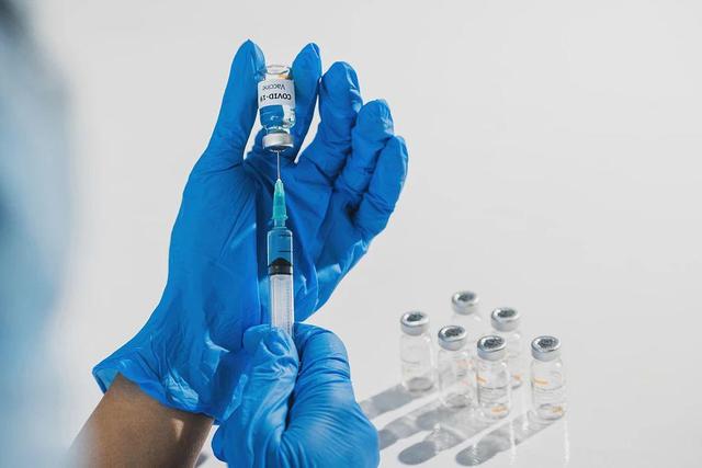 一名女医生手持注射器和疫苗瓶,用于治疗冠状病毒.图/视觉中国