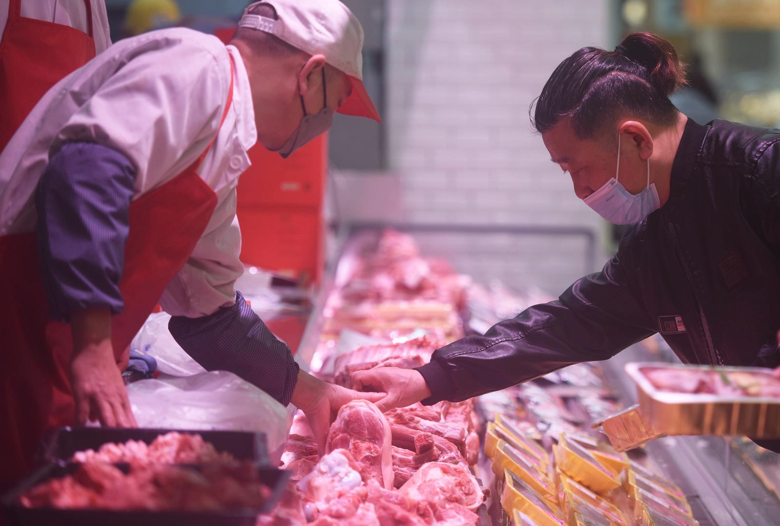 ↑2023年1月12日，杭州，顾客在一家超市选购猪肉。图据视觉中国