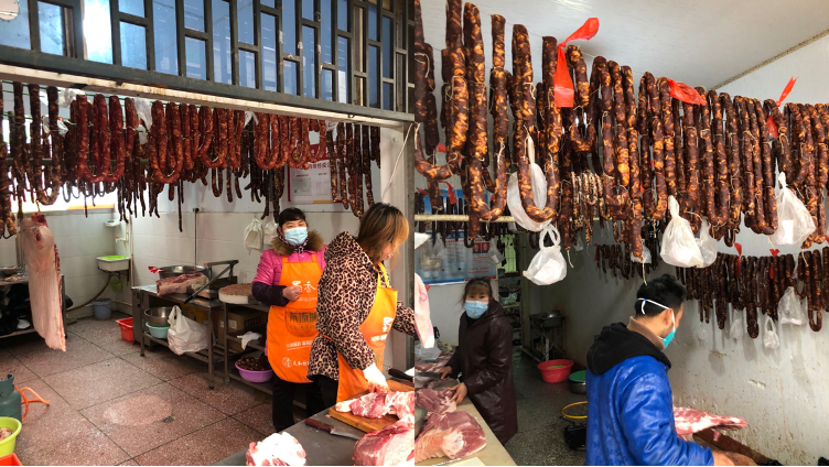 (肉铺吊挂香肠、打饺子馅等 财联社记者摄)