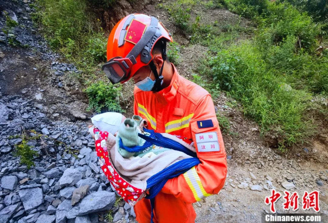 张自立怀抱在泸定地震中怀抱婴儿。阿坝森林消防支队供图