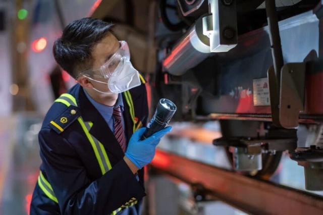 动车组随车机械师赵乐正在进行出库前的巡检作业.梁亮/摄