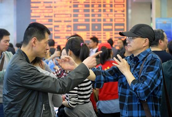 一次招聘会的现场,两名聋哑人职者在招聘会现场用手语进行交流.