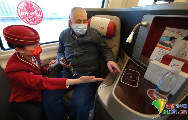 乘务人员指导老年旅客使用新设备.杨宝森 摄