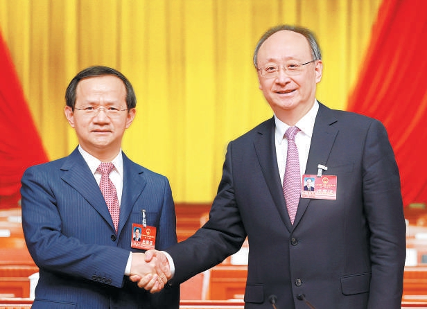 市委书记尹力与新当选的市长殷勇(左)紧紧握手,表示祝贺.
