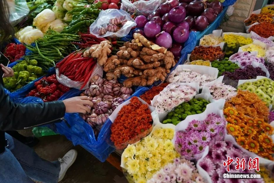 云南昆明大观篆新农贸市场,鲜花和蔬菜一起售卖也成为当地农贸市场的
