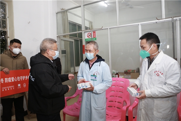 　　(复星全球合伙人、海南矿业总裁郭风芳将药品与爱心防疫包交到临高县基层村医手中)