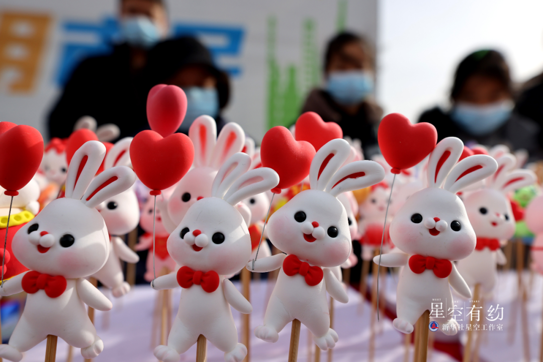 2023年1月15日,人们在山东省枣庄市齐村大集上选购面塑"萌兔".