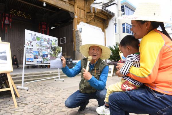 2022年05月17日，在建德市航头镇航川村，“堂前燕”宣讲员范胜利点评村民陆庆娟的手机摄影作品。新华社记者 翁忻旸 摄