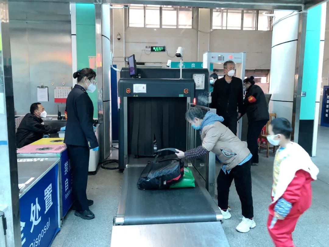 旅客把随身行李放在安检传送带.