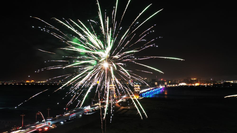 1月21日除夕夜,新年烟花在甘肃省张掖市黑河大桥上空绽放(无人机照片)