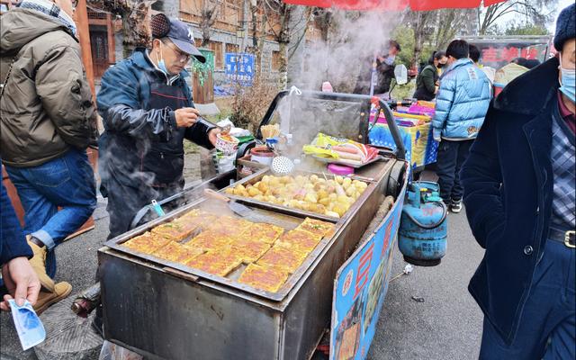 具有地方特色的小吃摊,摊主在为游客提供热气腾腾的炸洋芋和炸豆腐.