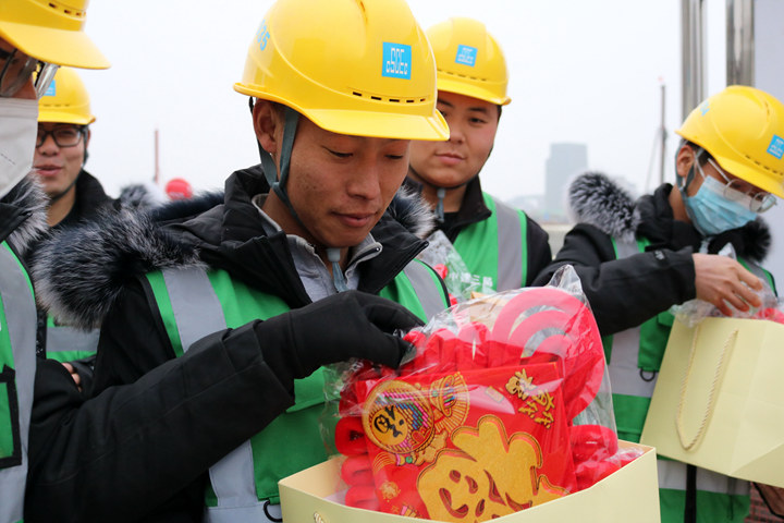 1月20日，中建三局北京公司河北雄安容西安置房项目坚守岗位的建筑工人收到“福”字等新年大礼包。新华社发