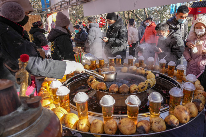 1月25日,游客在济南千佛山新春游园会上选购美食。新华社记者 朱峥 摄