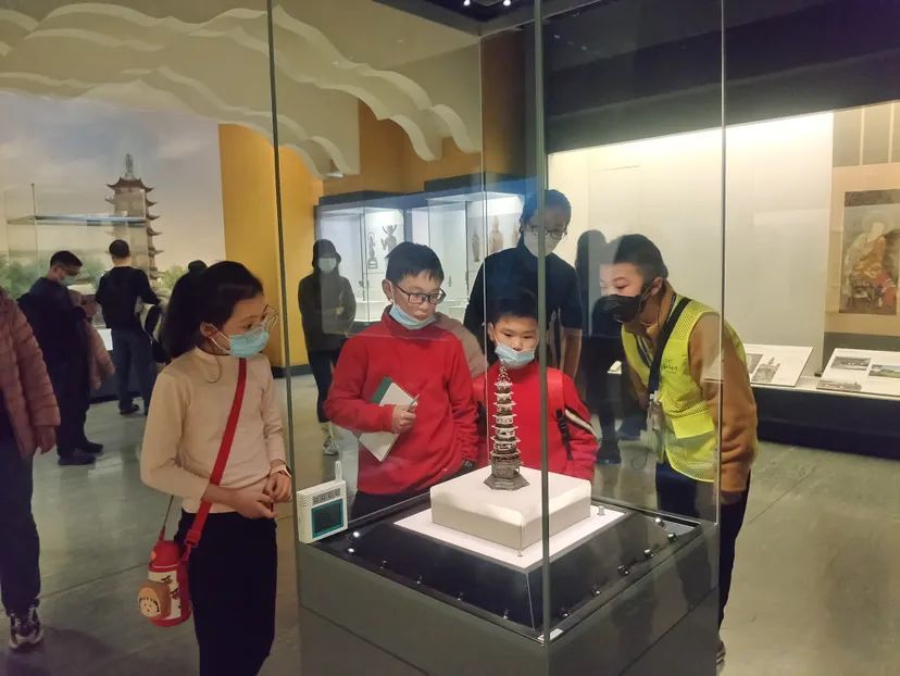 宁波七中初一年级的沈家禾（右一）在宁波博物馆给参观的同龄人讲解。