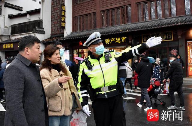 图为在夫子庙景区，执勤交警在为游客指路