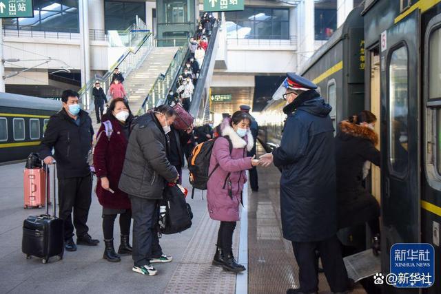 ↑1月27日，在新疆乌鲁木齐站，旅客排队上车。新华社记者 丁磊 摄