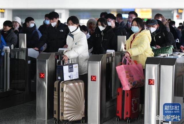 ↑1月27日，旅客在安徽省阜阳西站排队通过检票闸机准备乘车。新华社发（卢启建 摄）