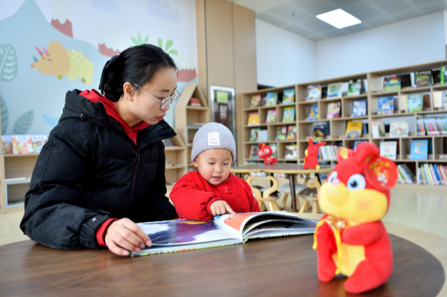 一名家长带着孩子阅读绘本。通讯员 杨韬 摄
