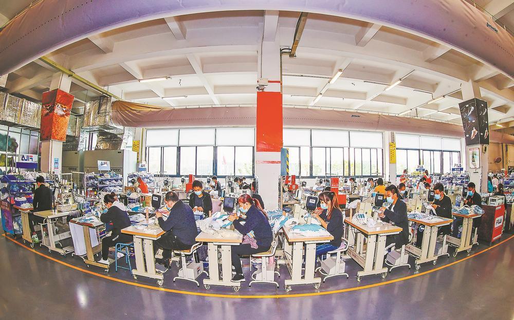 晋江市的安踏(中国)有限公司一车间里,工人在制鞋生产线上操作缝纫机