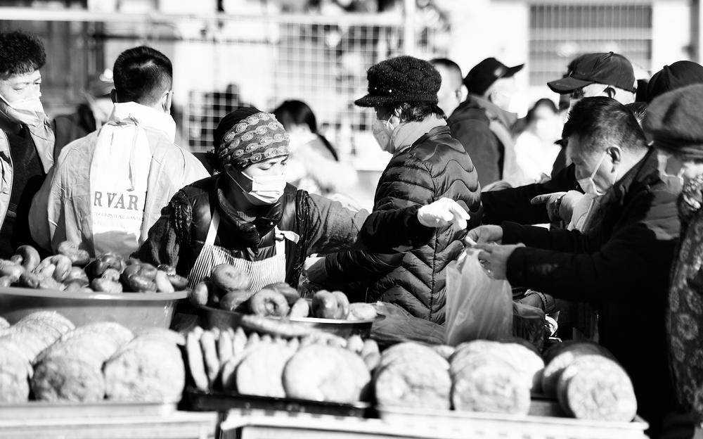 春节期间，在宁夏回族自治区的乡镇市集上，新鲜出锅的油饼、馓子等美食香气四溢，吸引村民纷纷前来购买。 本报记者 范文杰 摄