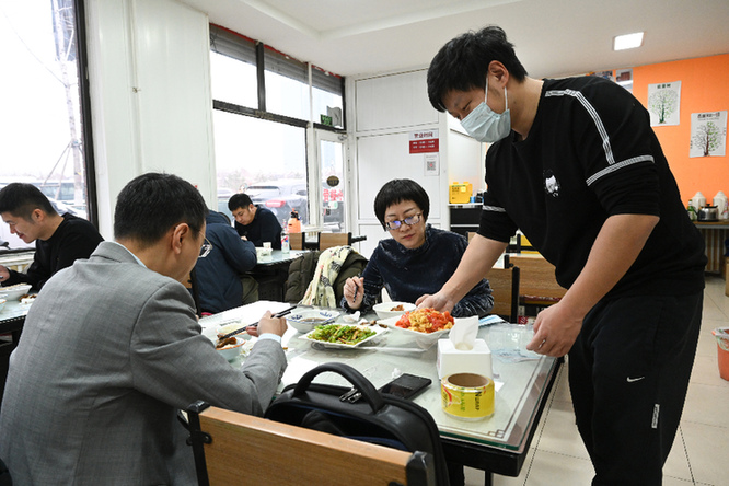 在北京军红发小排骨餐厅内，王兴谋正在给客人上菜。记者 潘悦 摄