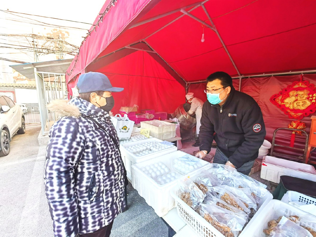 　　市民在小楼饭店摊位前选购元宵。记者 党维婷/摄