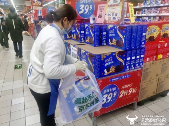 图为年货节期间，超市工作人员对京东到家订单中的亿滋礼盒拣货