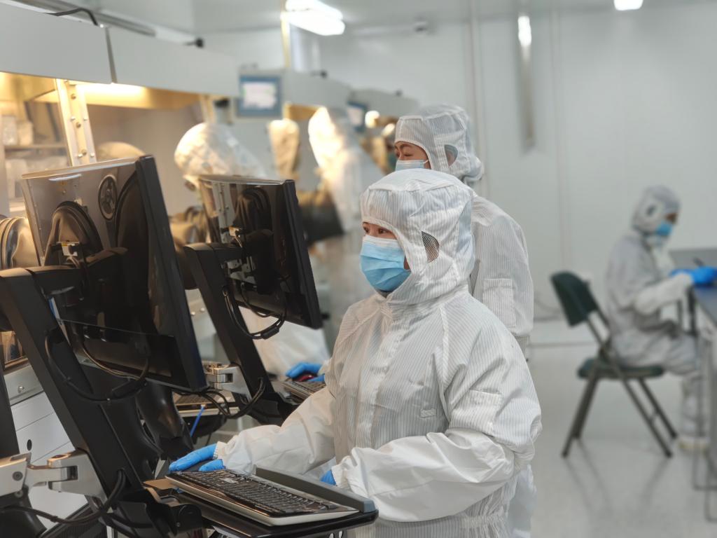 纤纳光电科研人员正在对氮气手套箱内实验工艺参数进行调整.